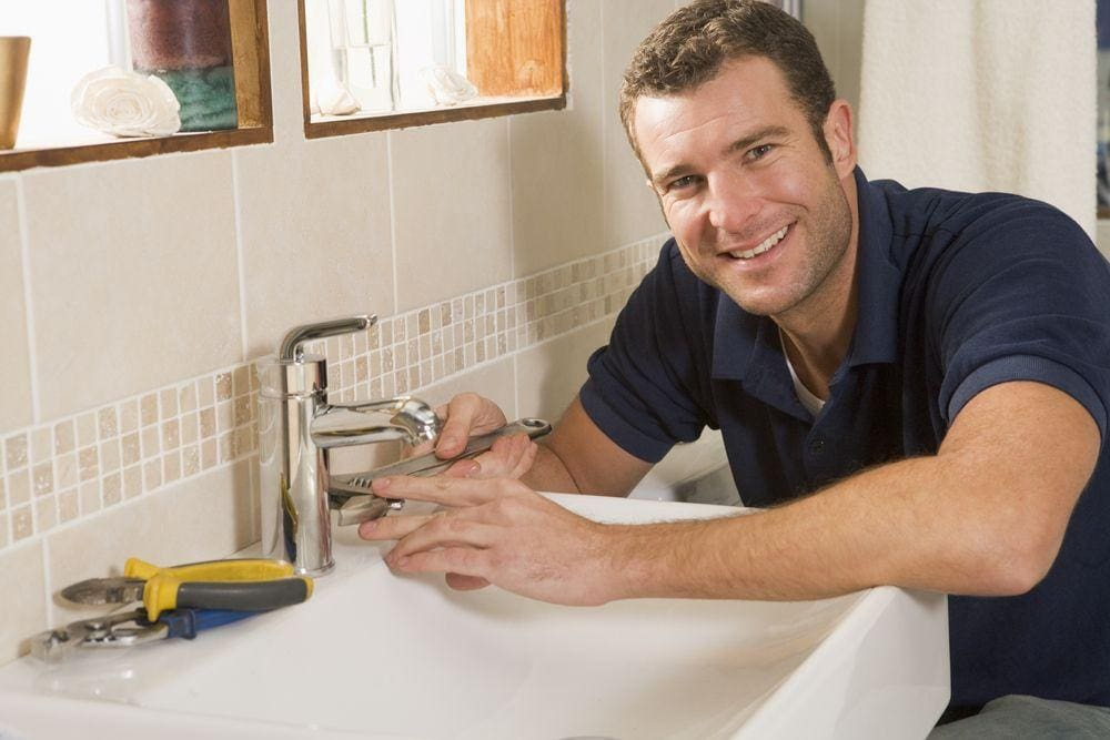 Bathroom Remodeling Contractor Carefully Installs New Bathroom Fixture